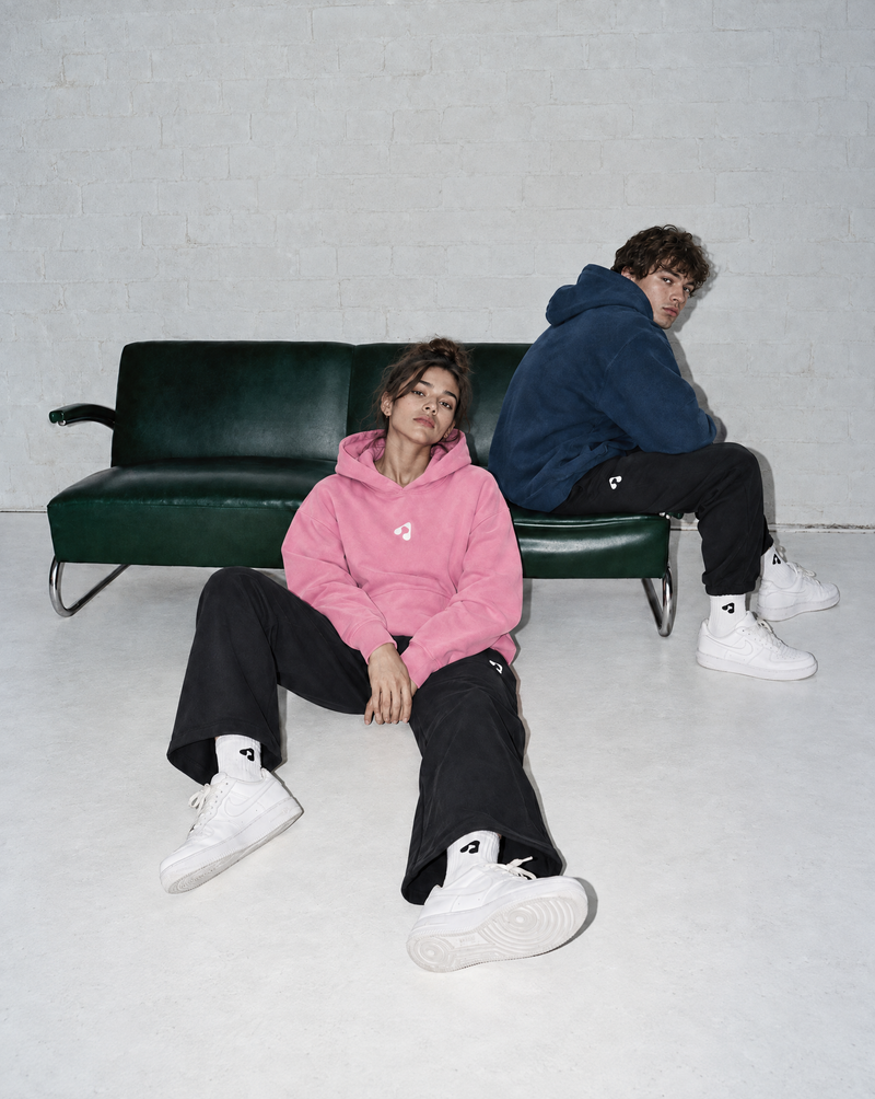 Man and woman wearing navy blue oversized Boost Sportswear T-shirts with relaxed-fit pants.