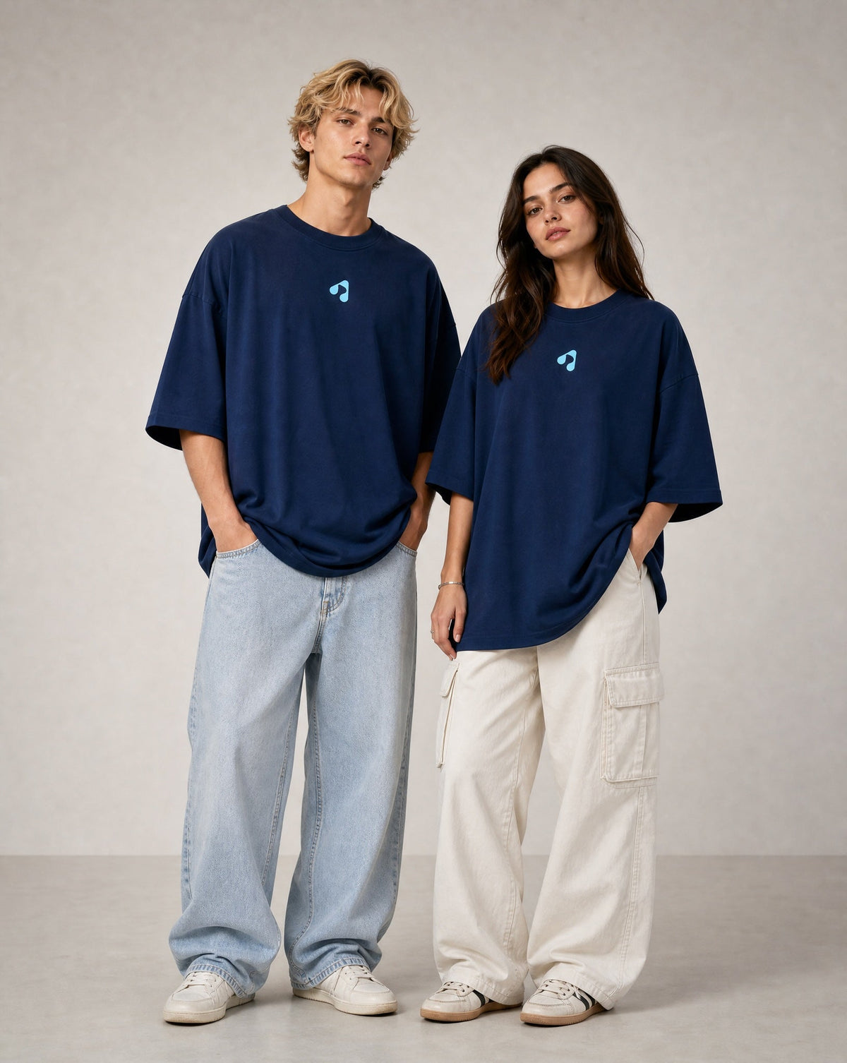 Man and woman wearing navy blue oversized Boost Sportswear T-shirts with relaxed-fit pants.